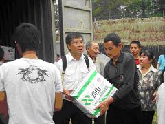 救世軍の支援ワーカー（陳少佐）が米、ビスケット、飲料水を彭州市の被災者に届ける。
