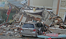 自動車の上に崩れ落ちた建物、パダン市内にて
