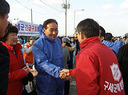道知事が救世軍に謝意を表して広報部書記官と握手、左は社会部書記官